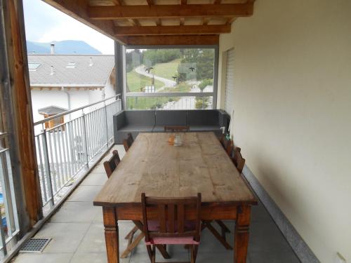 d'une table et de chaises en bois sur un balcon. dans l'établissement Vazerol, à Lenzerheide