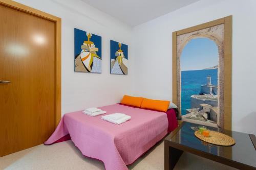 1 dormitorio con cama rosa, mesa y espejo en Puerta San FELIX free parking by Cadiz4Rentals, en Cádiz