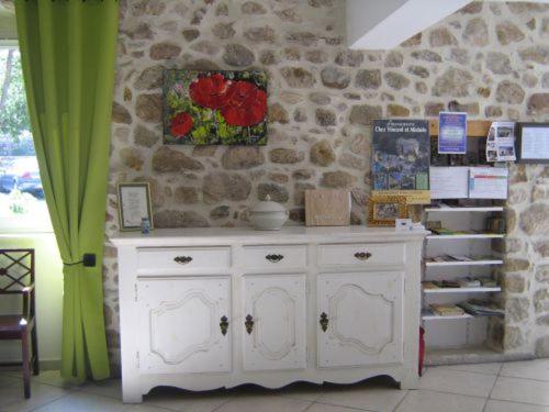 a white cabinet in a room with a stone wall at La musardière in Les Assions