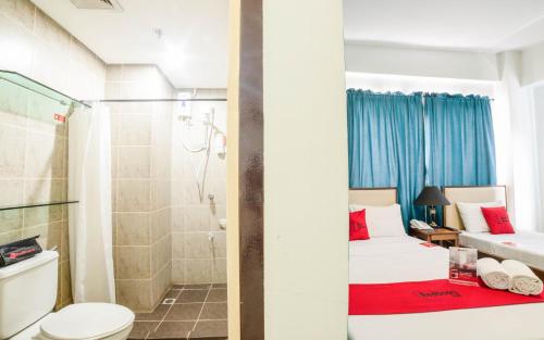 a bathroom with a bed and a shower and a toilet at RedDoorz Plus near Rizal Junction in Puerto Princesa City