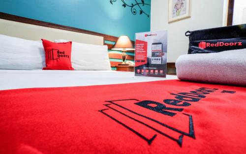 a bedroom with a red carpet on a bed at RedDoorz Plus near Rizal Junction in Puerto Princesa City