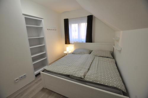 een kleine slaapkamer met een bed en een raam bij Prague Gardens Appartments in Praag