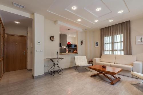 salon z kanapą i stołem w obiekcie Apartamento con encanto en el Barrio de Santa Cruz w Sewilli