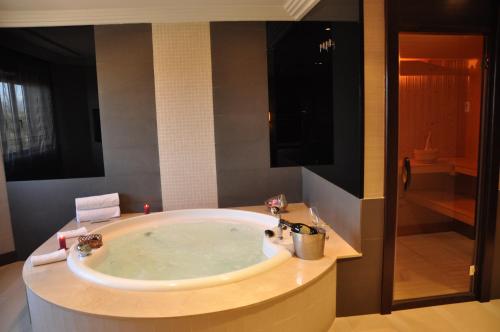 a bathroom with a large tub with a shower at Hotel Los Peñascales - Adults Only in Las Rozas de Madrid