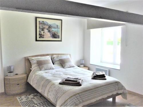 1 dormitorio blanco con 1 cama grande y ventana en Le Gite Sereine, en Berneuil