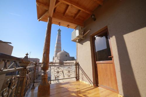 a balcony with a door and a tower in the background at Khiva Siyovush Hotel in Khiva