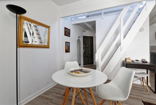 une salle à manger blanche avec une table blanche et des chaises blanches dans l'établissement Les Salins de Batz-sur-mer, à Batz-sur-Mer
