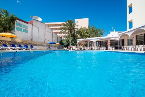 una grande piscina con sedie e un edificio di Hotel Santa Maria Playa a Cala Millor