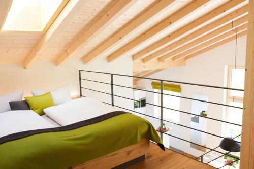 a bedroom with a green bed with a glass wall at Haus FreiRaum in Fischen