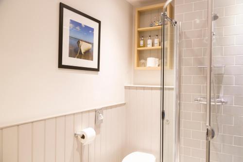 a bathroom with a shower stall and a toilet at The White Horse Blakeney in Blakeney