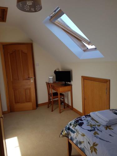 a bedroom with a bed and a desk with a computer at Kilcreeny Lodge in Lisburn