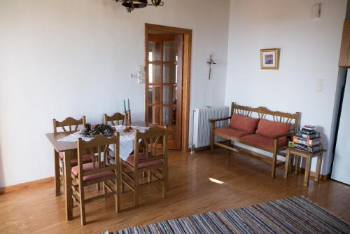 a living room with a table and chairs and a couch at Pelion House with Wonderful View in Vizitsa