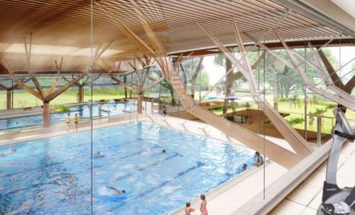 une grande piscine dans un grand bâtiment dans l'établissement Millygite roulotte - 4 seasons Chalet-on-wheels, à Milly-la-Forêt