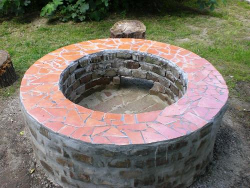 a brick fire pit in the middle of a yard at Kurca-parti Vendégház in Szentes