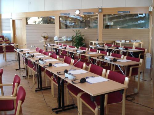 a dining room with rows of tables and red chairs at Nordiska Folkhögskolan Bed and Breakfast in Kungälv