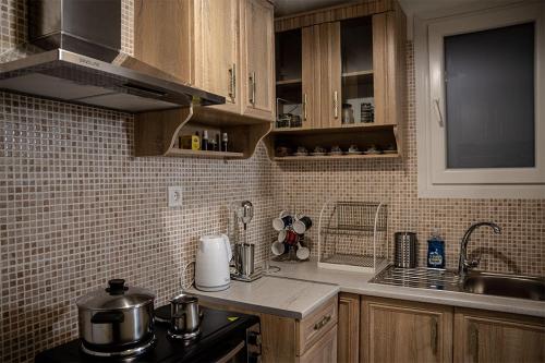 una cucina con armadi in legno e piano di lavoro di Your apartment in Athens (Next to Metro & Acropolis) ad Atene