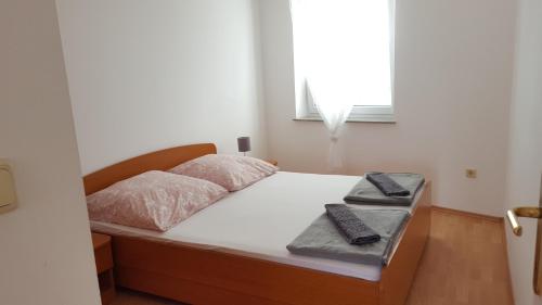 a bedroom with a bed with two remote controls on it at Zagi in Povljana