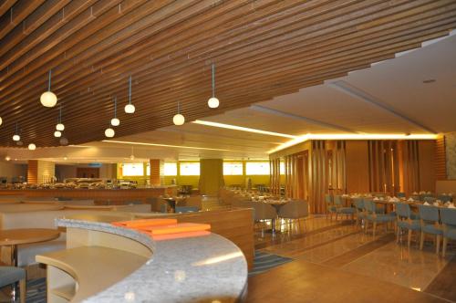 a restaurant with tables and chairs and a bar at Lavender Hotel Al Nahda Dubai in Dubai
