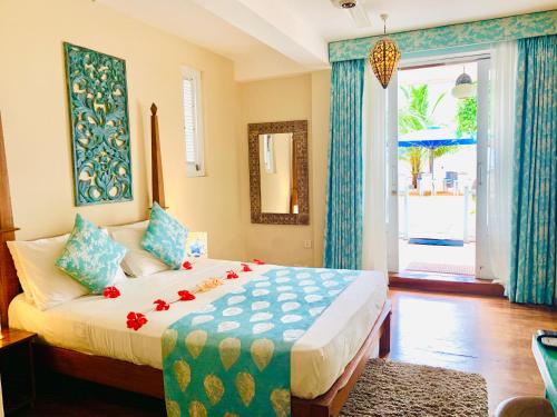 a bedroom with a large bed and a large window at Thaproban Beach House in Unawatuna