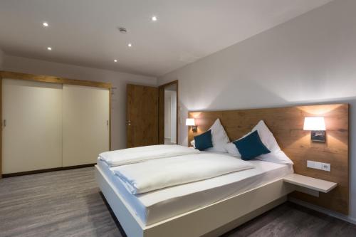 a bedroom with a large white bed with blue pillows at Boardinghouse E68 in Schliengen