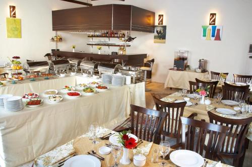 a dining room with tables and chairs with dishes on them at Bacahan Hotel in Altınoluk