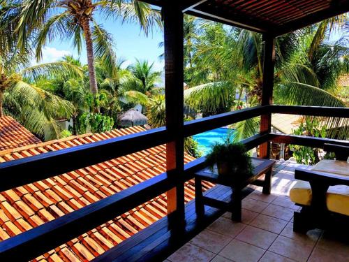 a balcony with a view of the ocean and palm trees at Hotel e Pousada La Dolce Vita in Canoa Quebrada