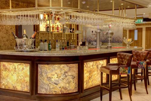 a bar in a hotel with a counter and chairs at Best Western Premier Doncaster Mount Pleasant Hotel in Doncaster