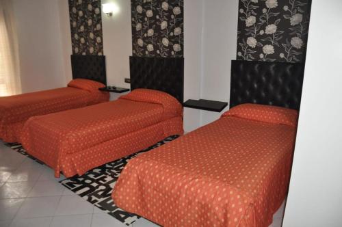 a room with two orange beds at Hôtel Marina in Tetouan
