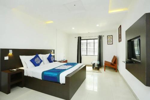 a bedroom with a bed and a television in it at Half Moon Residency Calicut in Kozhikode