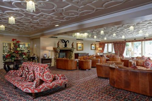 Best Western Premier Doncaster Mount Pleasant Hotel في دونكاستير: لوبى به أريكة وكراسي ومدفأة