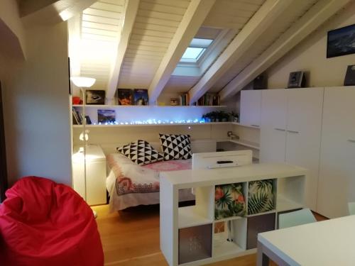 una pequeña habitación con una cama y una mesa en Mansarda Del Sole, Nel Cuore Di Aosta, en Aosta