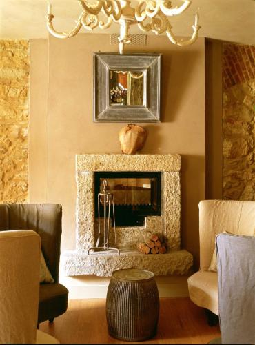 a living room with a fireplace and a chandelier at Albergo l'Ostelliere - Villa Sparina Resort in Gavi