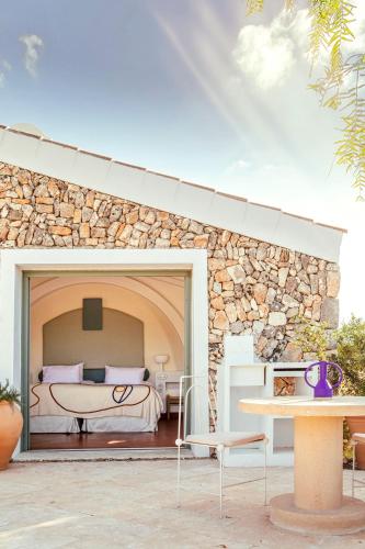 a bedroom with a bed and a stone wall at Menorca Experimental in Alaior