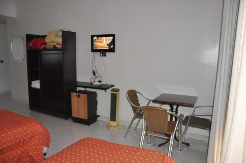 a living room with a tv and a table and chairs at Hôtel Marina in Tetouan