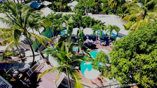 an overhead view of a resort swimming pool with palm trees at Duplex 4 personnes Chambre vue mer Résidence O Coeur de Deshaies in Deshaies