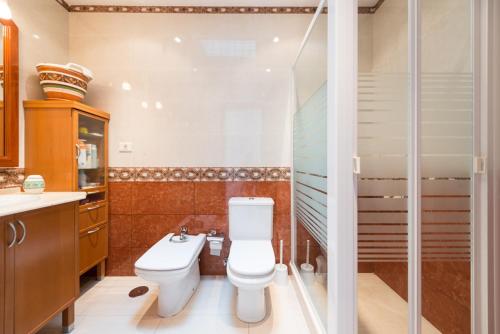 een badkamer met een toilet en een douche bij Villa Cosmos chalet con gran piscina y jardin privado in Maspalomas
