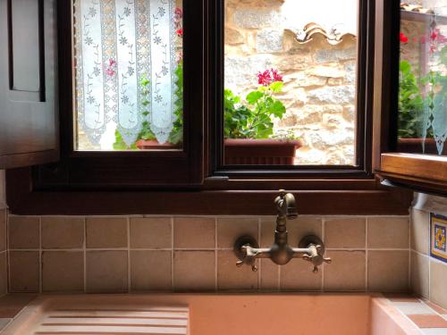 a kitchen sink with two windows and a faucet at Casa Masini in Fonni
