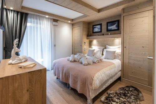 a bedroom with a large bed with two stuffed animals on it at Annapurna by Alpine Resorts in Les Gets