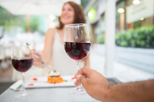 a person holding up a glass of red wine at Ibis Styles Palermo Cristal in Palermo