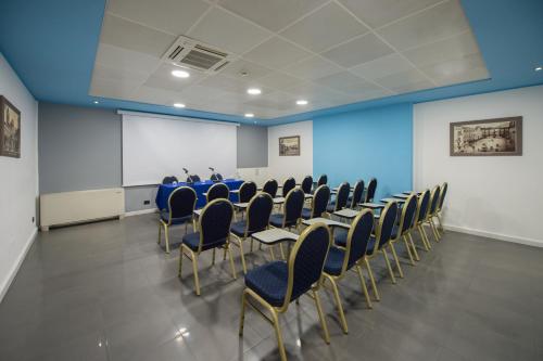 a conference room with a table and chairs and a screen at Ibis Styles Palermo Cristal in Palermo