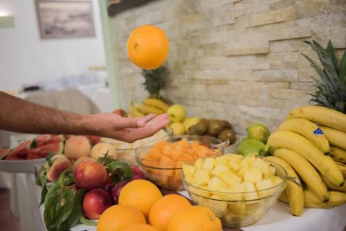 a person is reaching for an orange above a table of fruit at Ibis Styles Palermo Cristal in Palermo