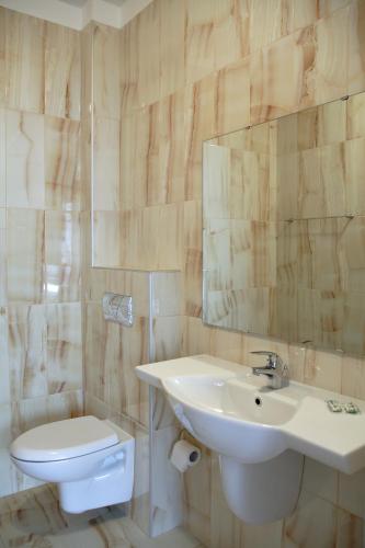 a bathroom with a sink and a toilet and a mirror at BLOCK 531 ApartHouse BLOCK 533 in Sofia