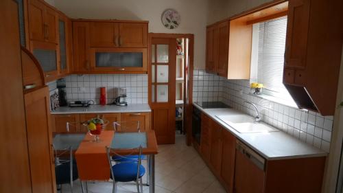 a kitchen with wooden cabinets and a table with chairs at Villa with the view of Palamidi and Bourtzi in Nafplio