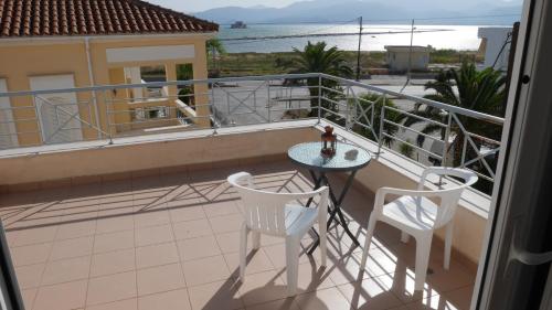 a balcony with a table and two chairs and a view of the ocean at Villa with the view of Palamidi and Bourtzi in Nafplio