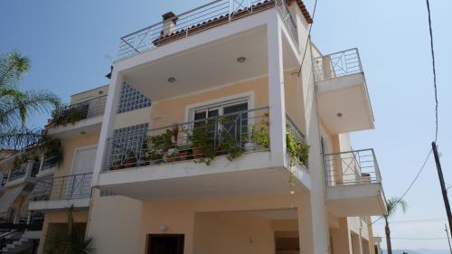 a white building with balconies and plants on it at Villa with the view of Palamidi and Bourtzi in Nafplio