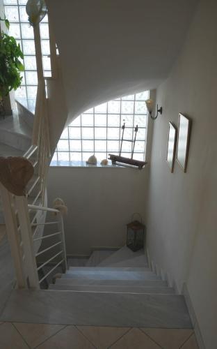 a spiral staircase in a room with two windows at Villa with the view of Palamidi and Bourtzi in Nafplio