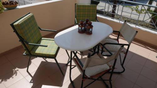 a table and two chairs on a balcony at Villa with the view of Palamidi and Bourtzi in Nafplio
