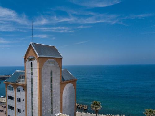 a building with a clock tower next to the ocean at Boyokaku in Amakusa