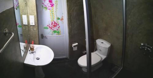 a bathroom with a toilet and a sink and a mirror at Grace Green Ville in Negombo
