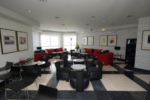un restaurante con sillas y mesas negras y sillas rojas en Hotel Los Peñascales - Adults Only, en Las Rozas de Madrid